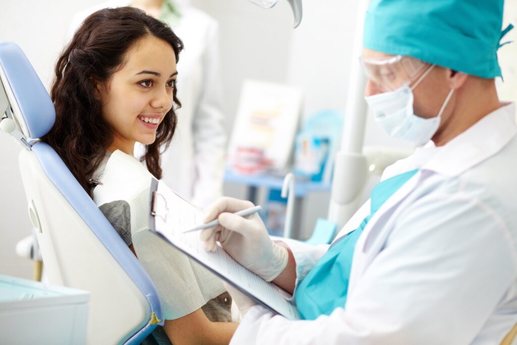 dentist_checking_patient_writing_on_clipboard_